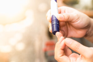 close up of a woman 's hands using lancet on finger